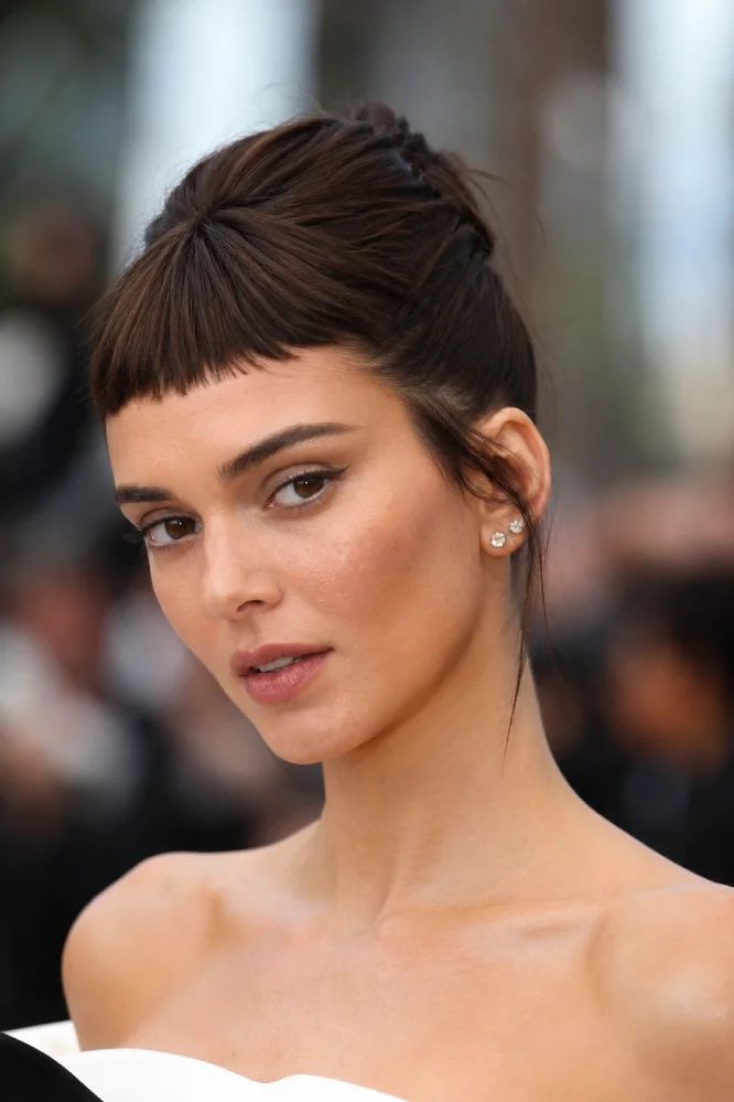 Woman with short micro bangs (baby bangs) and an elegant updo.