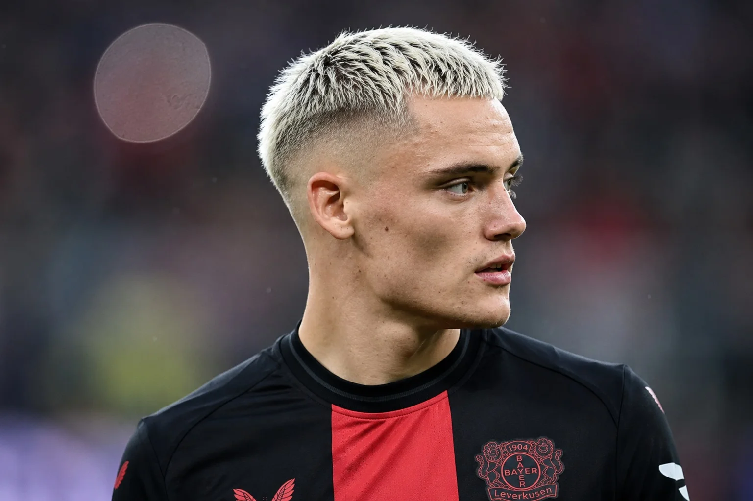 Florian Wirtz with bleached blond hair featuring a light taper fade and textured top during his blond hairstyle phase