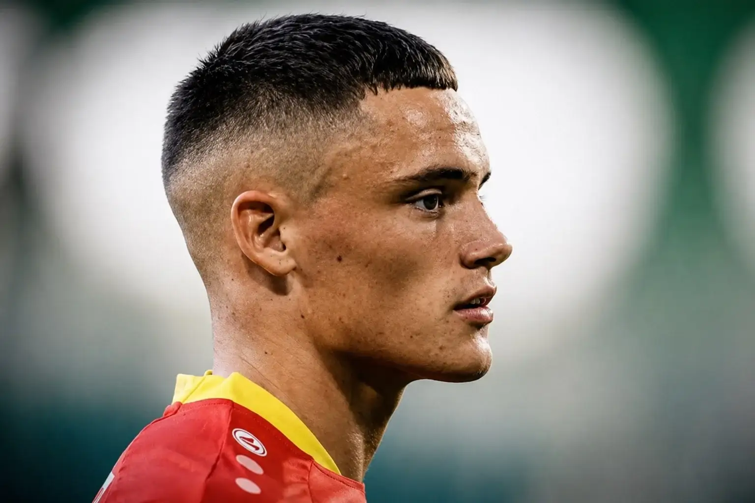 Close up side profile of Florian Wirtz showing his textured hairstyle with a light taper fade and short textured top